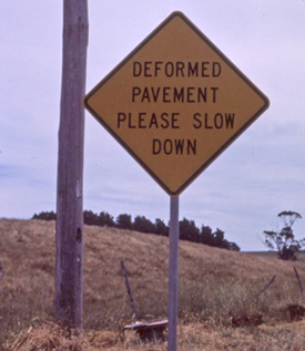 deformed pavement road sign